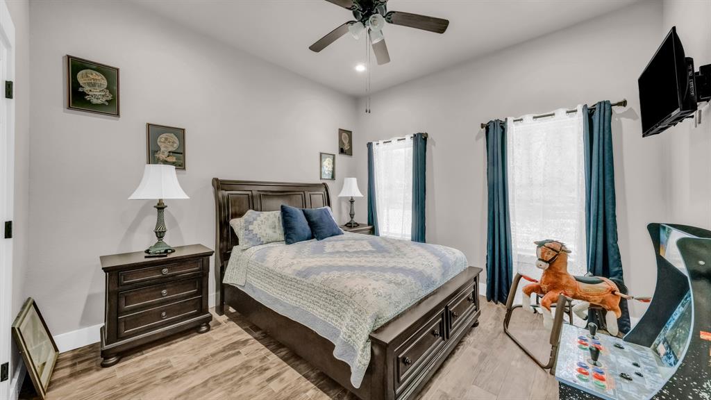 143 Oak Tree Drive Poolville, TX 76487 - Photo 26 of 40 a bedroom with a bed and a chandelier