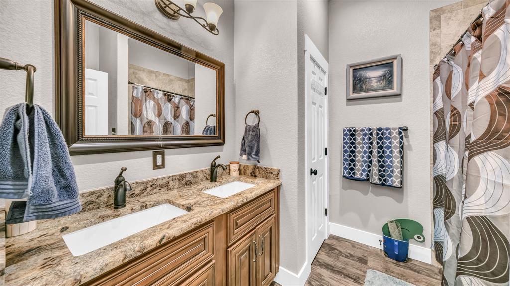 143 Oak Tree Drive Poolville, TX 76487 - Photo 27 of 40 a bathroom with a sink double vanity and a mirror