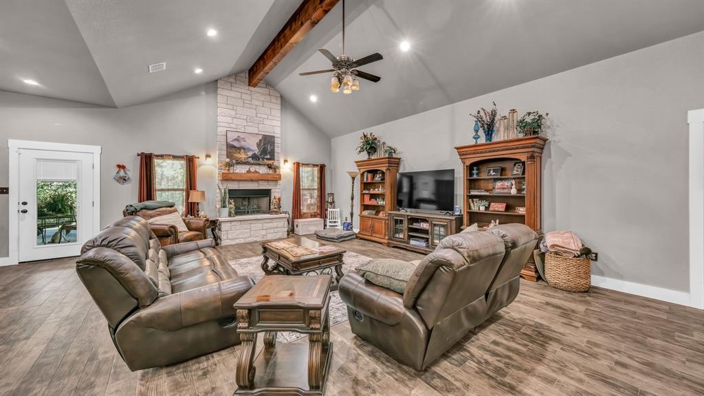 143 Oak Tree Drive Poolville, TX 76487 - Photo 7 of 40 a living room with furniture ceiling fan and a wooden floor