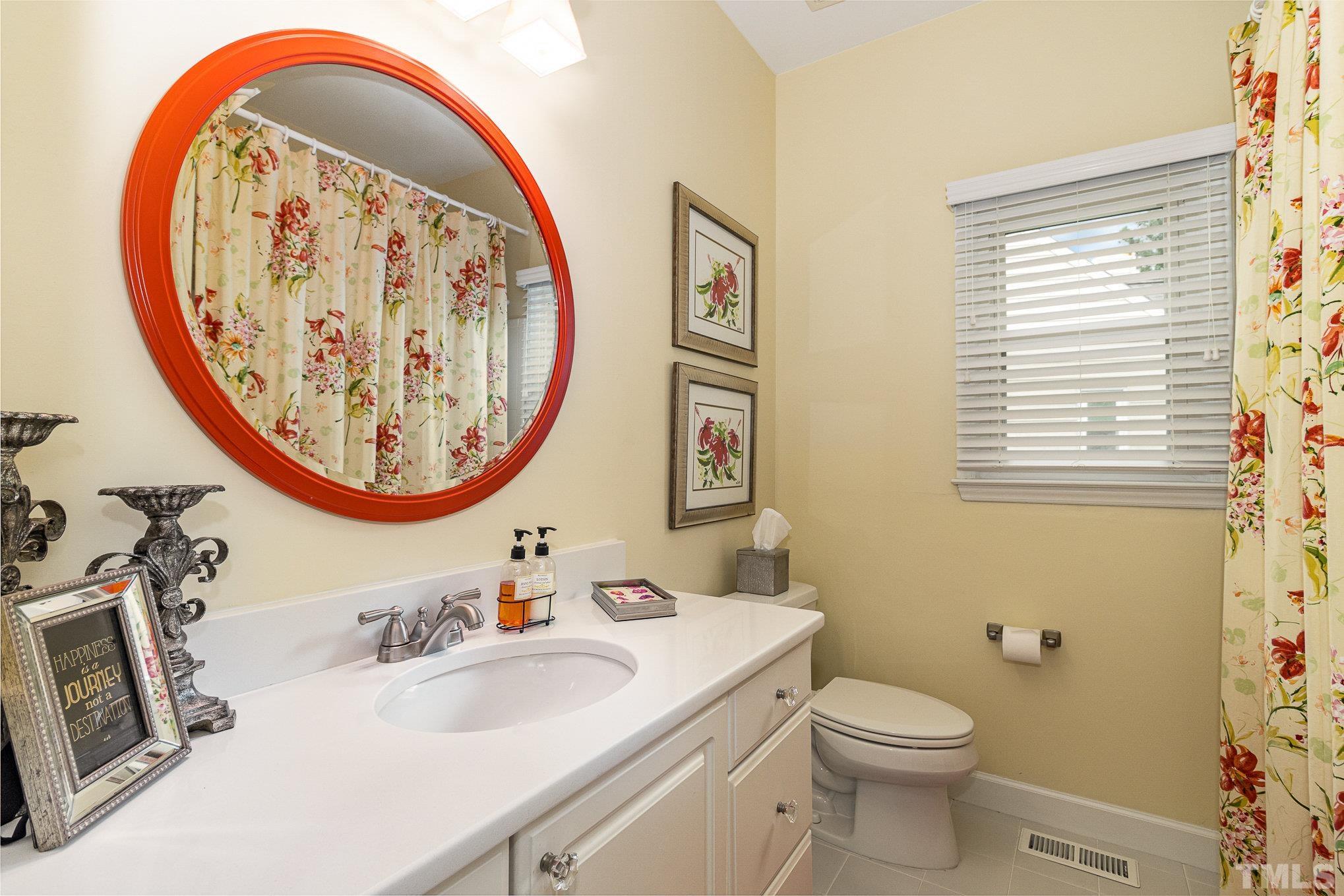 313 Boltstone Court Cary, NC 27513 - Photo 19 of 28 a bathroom with a sink a mirror and a toilet