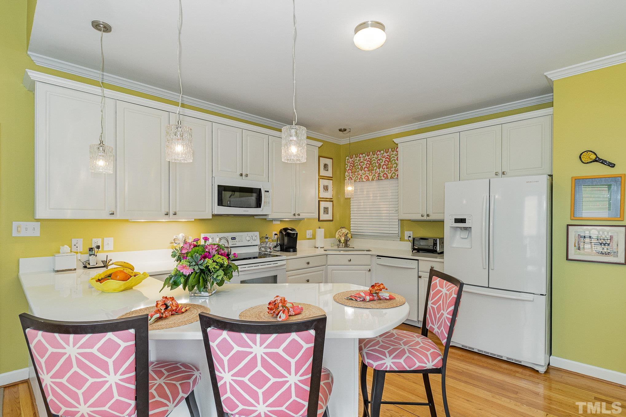 313 Boltstone Court Cary, NC 27513 - Photo 9 of 28 a kitchen with stainless steel appliances granite countertop a dining table chairs refrigerator and sink