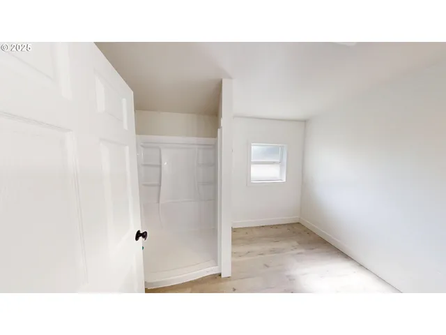 a open living room with a white wall and closet