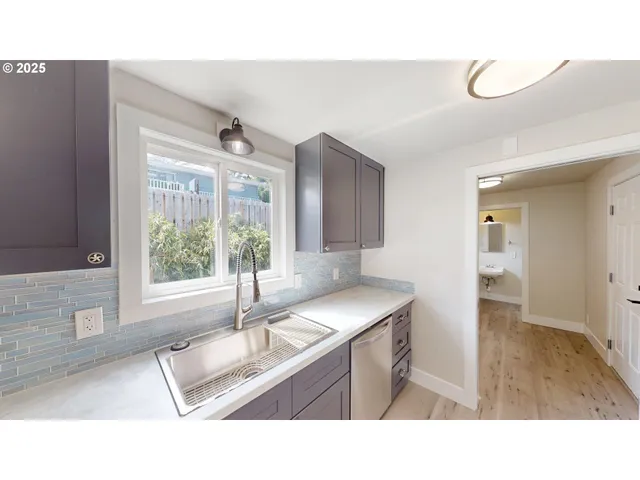 a kitchen with a sink large window and cabinets