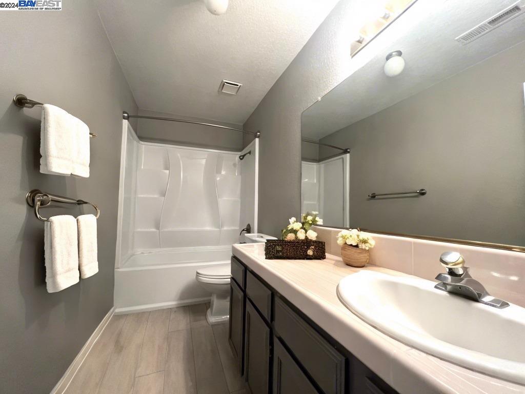 95377 Scott Tracy, CA 93577 - Photo 12 of 46 a bathroom with a double vanity sink toilet mirror and bathtub
