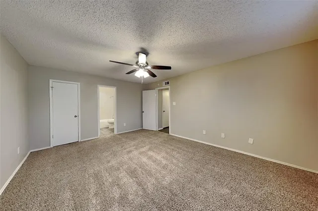 a view of an empty room with a chandelier fan