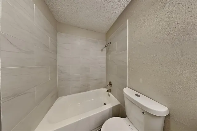 a white toilet sitting next to a bath tub