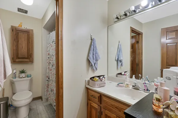 a bathroom with a sink vanity mirror and toilet