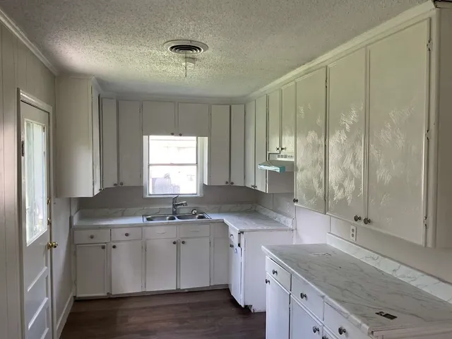 a kitchen with a sink window and cabinets