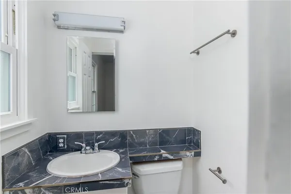 a bathroom with a toilet sink and mirror