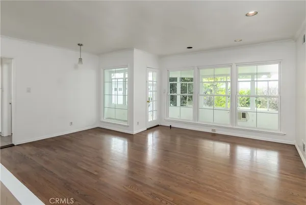 a view of wooden floor and windows in a room