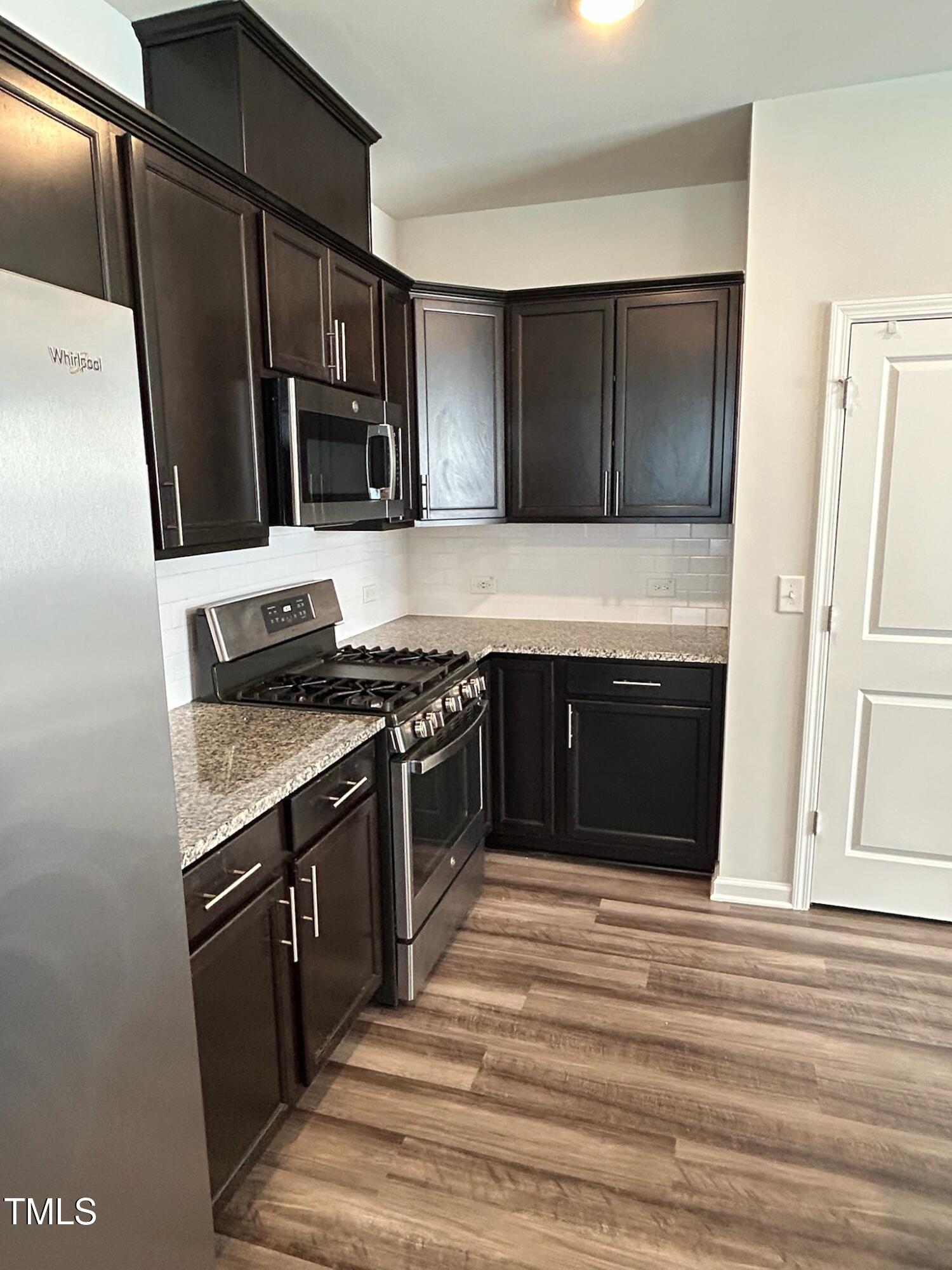 103 Bedivere Lane Durham, NC 27703 - Photo 6 of 25 a kitchen with stainless steel appliances granite countertop a stove and a refrigerator
