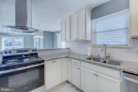 a kitchen with stainless steel appliances granite countertop a sink stove and cabinets