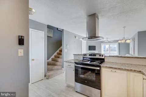 a kitchen with granite countertop a stove and a sink