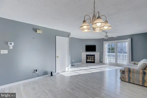 a view of a livingroom with wooden floor and a ceiling fan