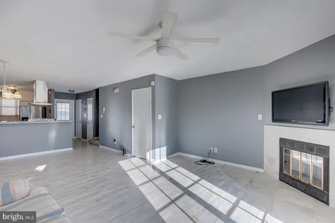a view of a livingroom with wooden floor and a kitchen space