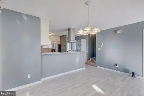 a view of a room with wooden floor and chandelier