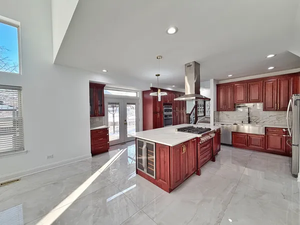 a large kitchen with a stove a refrigerator a sink dishwasher with a dining table and chairs