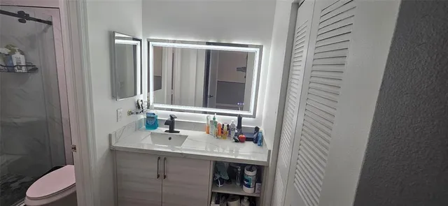 a bathroom with a granite countertop sink and a mirror