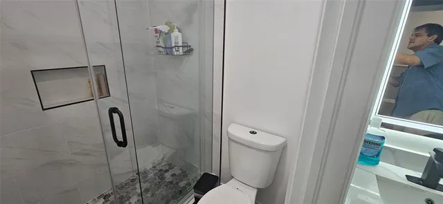 a bathroom with a toilet and a shower
