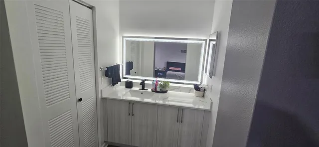 a bathroom with a sink vanity and mirror