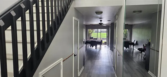 a view of a hallway with dining room and wooden floor