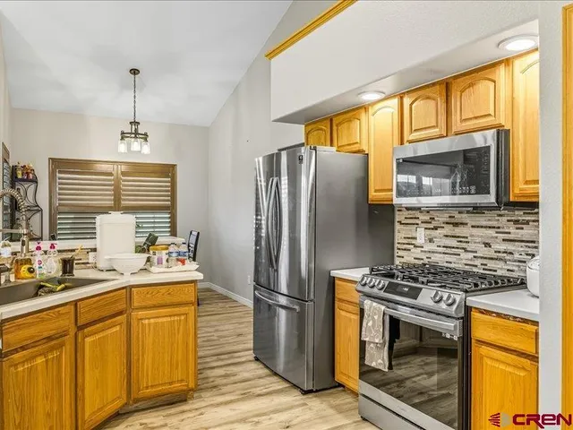 a kitchen with stainless steel appliances a stove a refrigerator and a sink