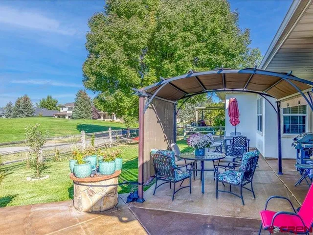 a patio with wooden table and chairs