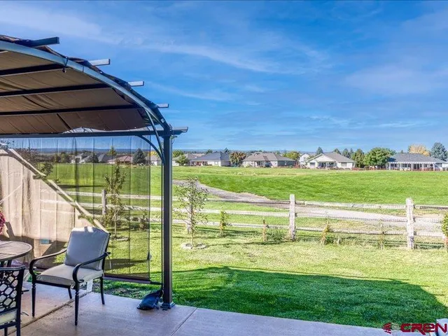 a view of swimming pool with lawn chairs and a big yard