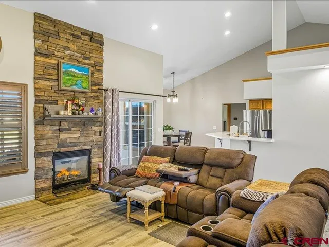 a living room with furniture a fireplace and a floor to ceiling window