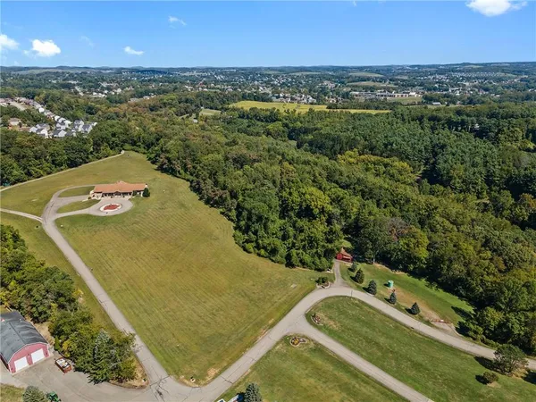 an aerial view of a house with a yard and lake view