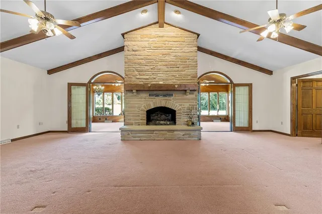 a view of an empty room with a fireplace and a chandelier