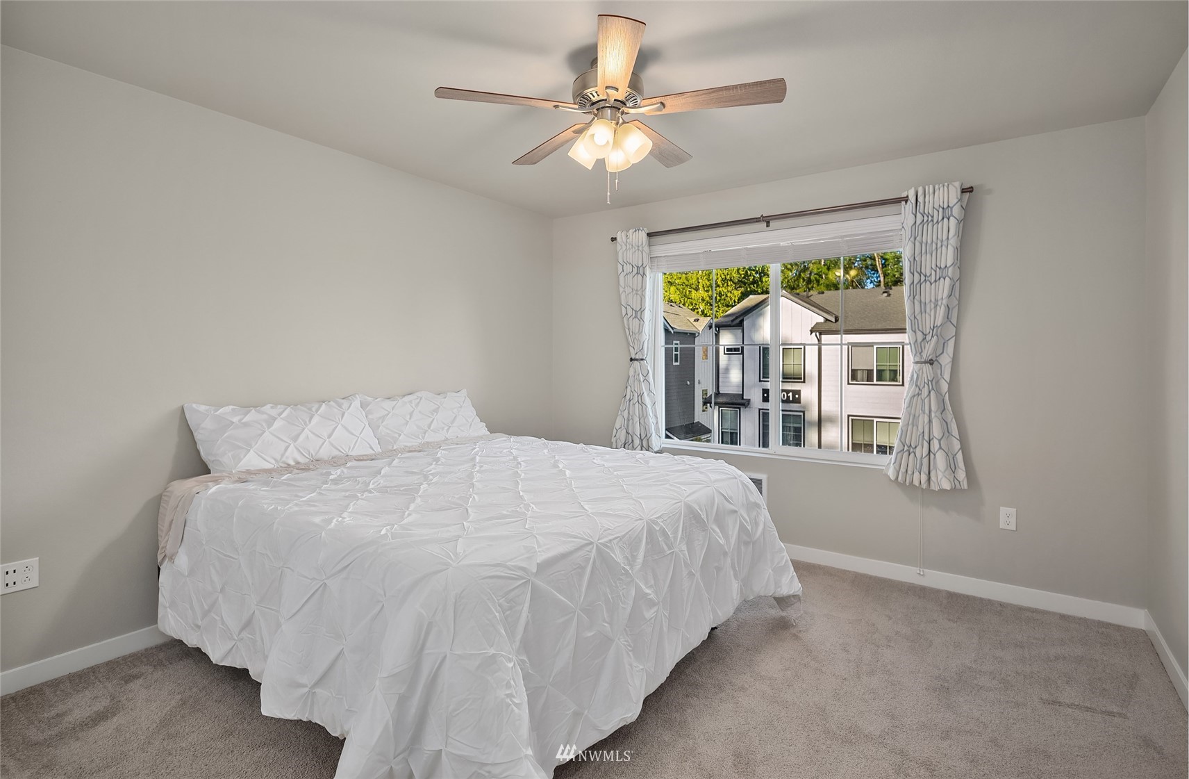 2002 101st Avenue Southeast, Unit 2 Lake Stevens, WA 98258 - Photo 19 of 22 a large bed sitting in a bedroom next to a window