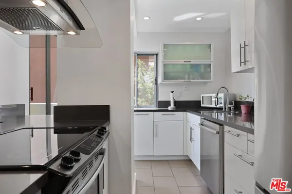 a kitchen with white cabinets a sink and dishwasher