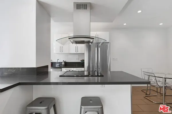 a kitchen with stainless steel appliances granite countertop a refrigerator and a stove top oven