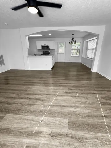 a view of a living room with furniture and a wooden floor