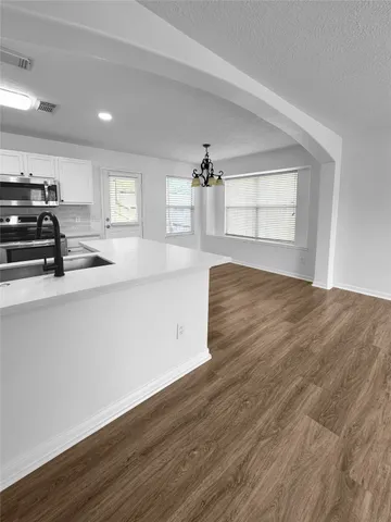 a kitchen with a sink cabinets and wooden floor