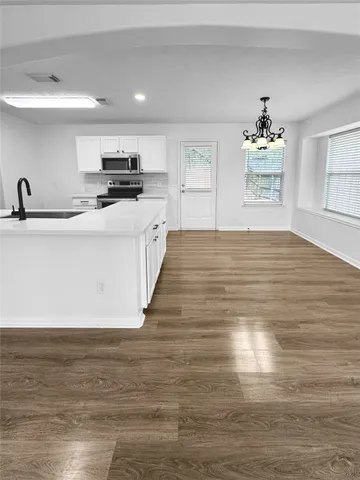 a view of kitchen with sink microwave and cabinets