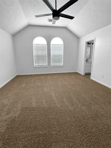 an empty room with windows and chandelier fan