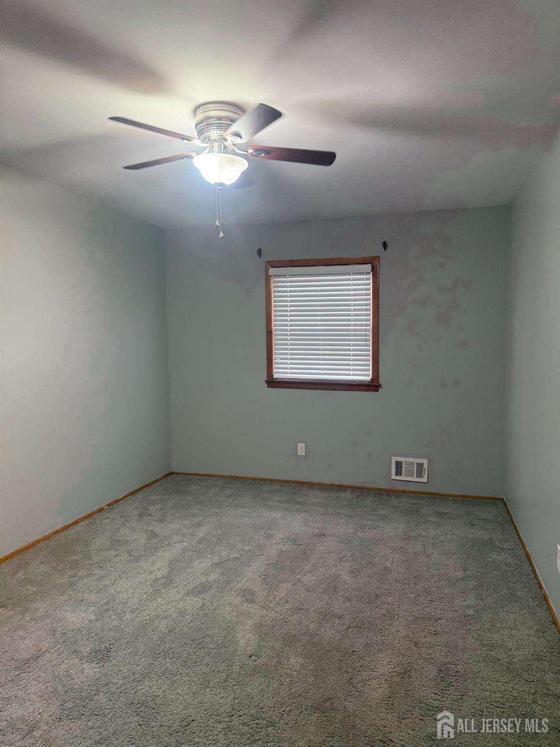 55 Murdock Street Fords, NJ 08863 - Photo 2 of 6 an empty room with a chandelier fan and windows