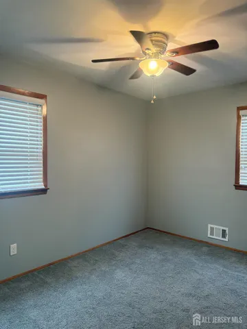 a view of an empty room with a chandelier fan