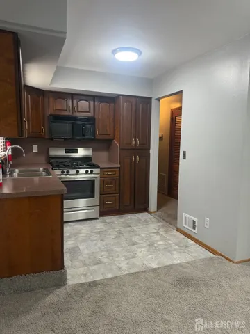 a kitchen with stainless steel appliances granite countertop a refrigerator and a stove top oven