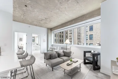 a living room with furniture and floor to ceiling windows