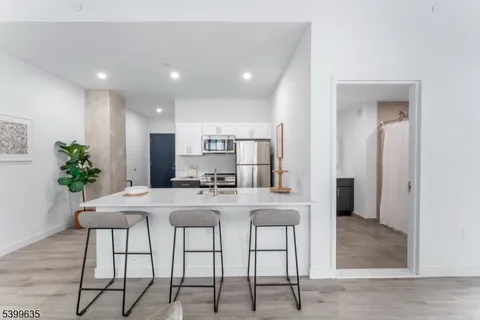 a kitchen with kitchen island granite countertop a refrigerator and a stove