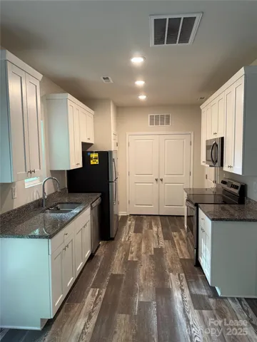 a kitchen with granite countertop a sink and cabinets