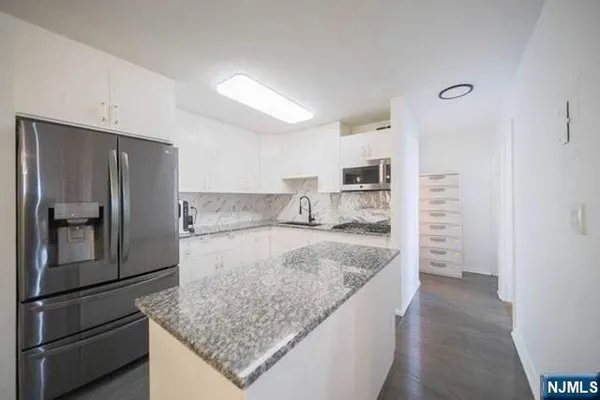 a kitchen with stainless steel appliances granite countertop a refrigerator and a sink