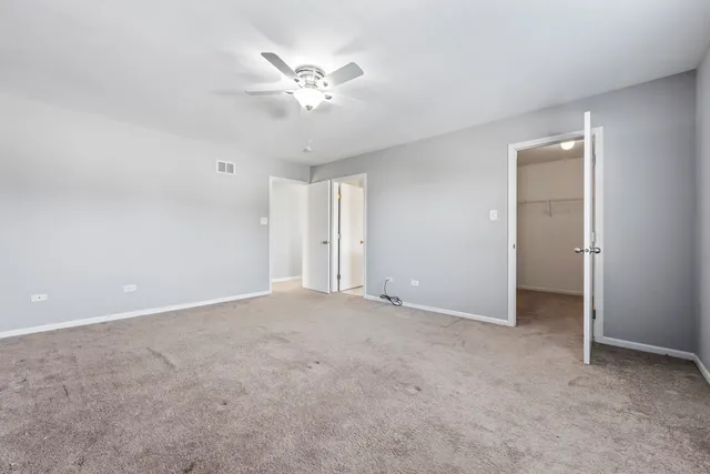 an empty room with chandelier fan