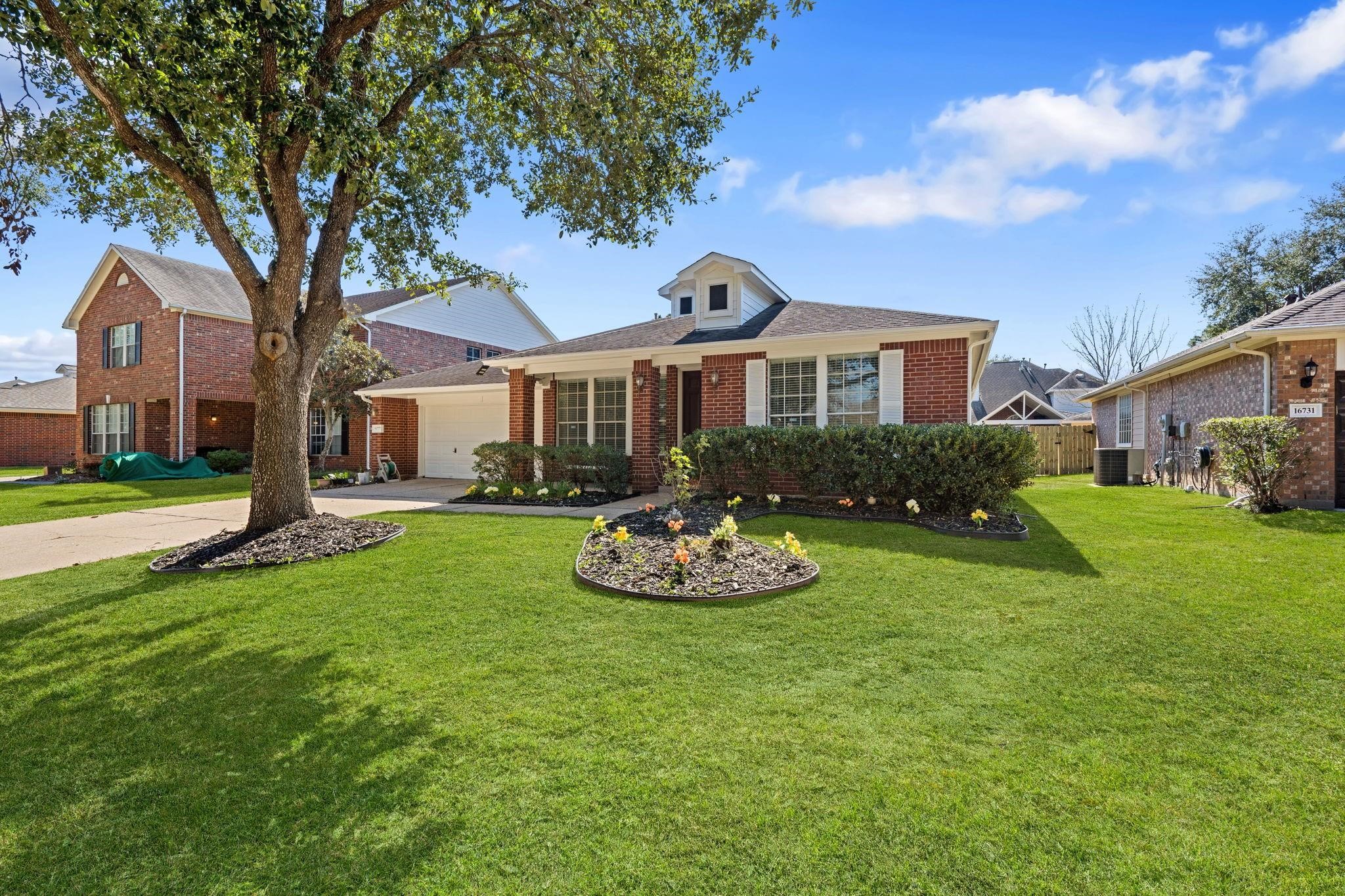 a front view of a house with a garden and trees