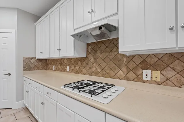 a kitchen with white cabinets and appliances