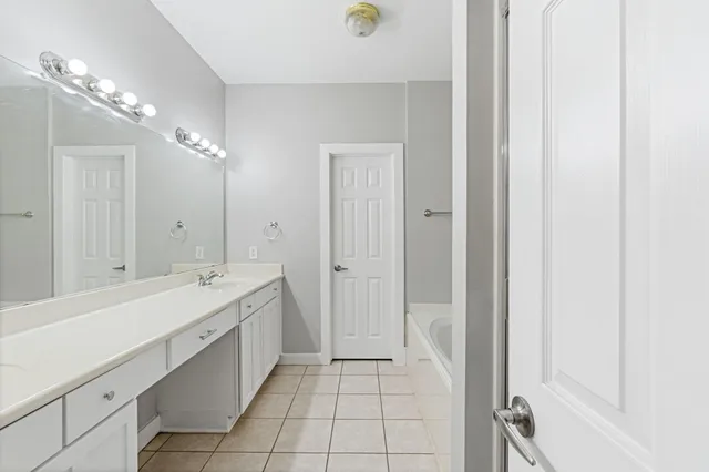 a large bathroom with a double vanity sink a large mirror and a shower