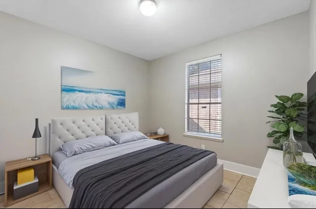 a bedroom with a large bed and a potted plant